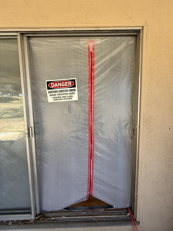 Sealed containment entry with an asbestos danger sign