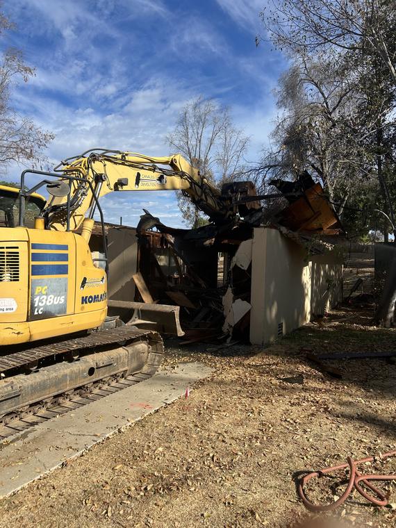 Excavator taking down a house